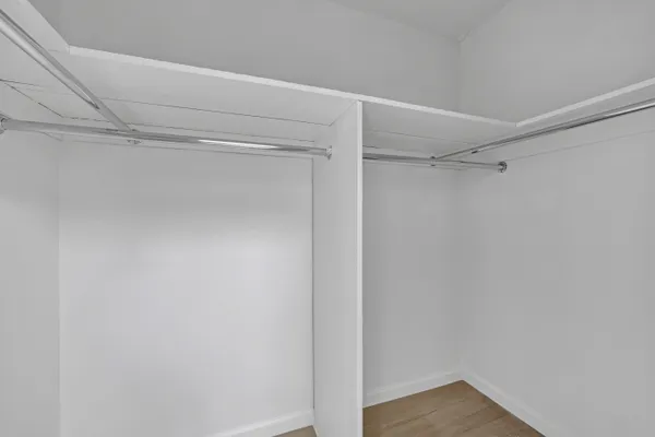 a view of walk in closet with empty racks