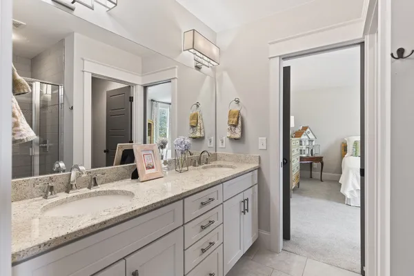 a en suite bathroom with a granite countertop sink and a mirror