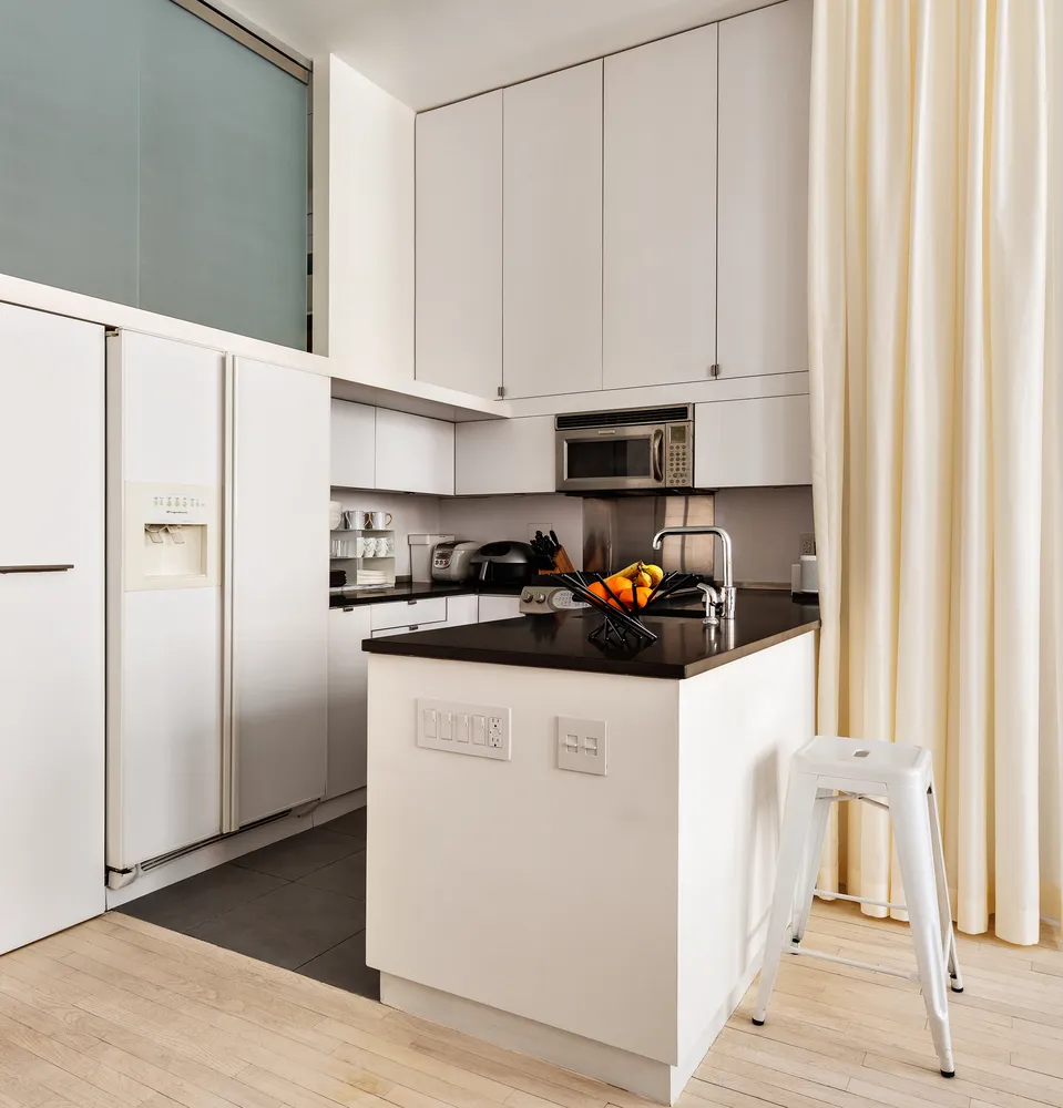 a kitchen with white cabinets and refrigerator