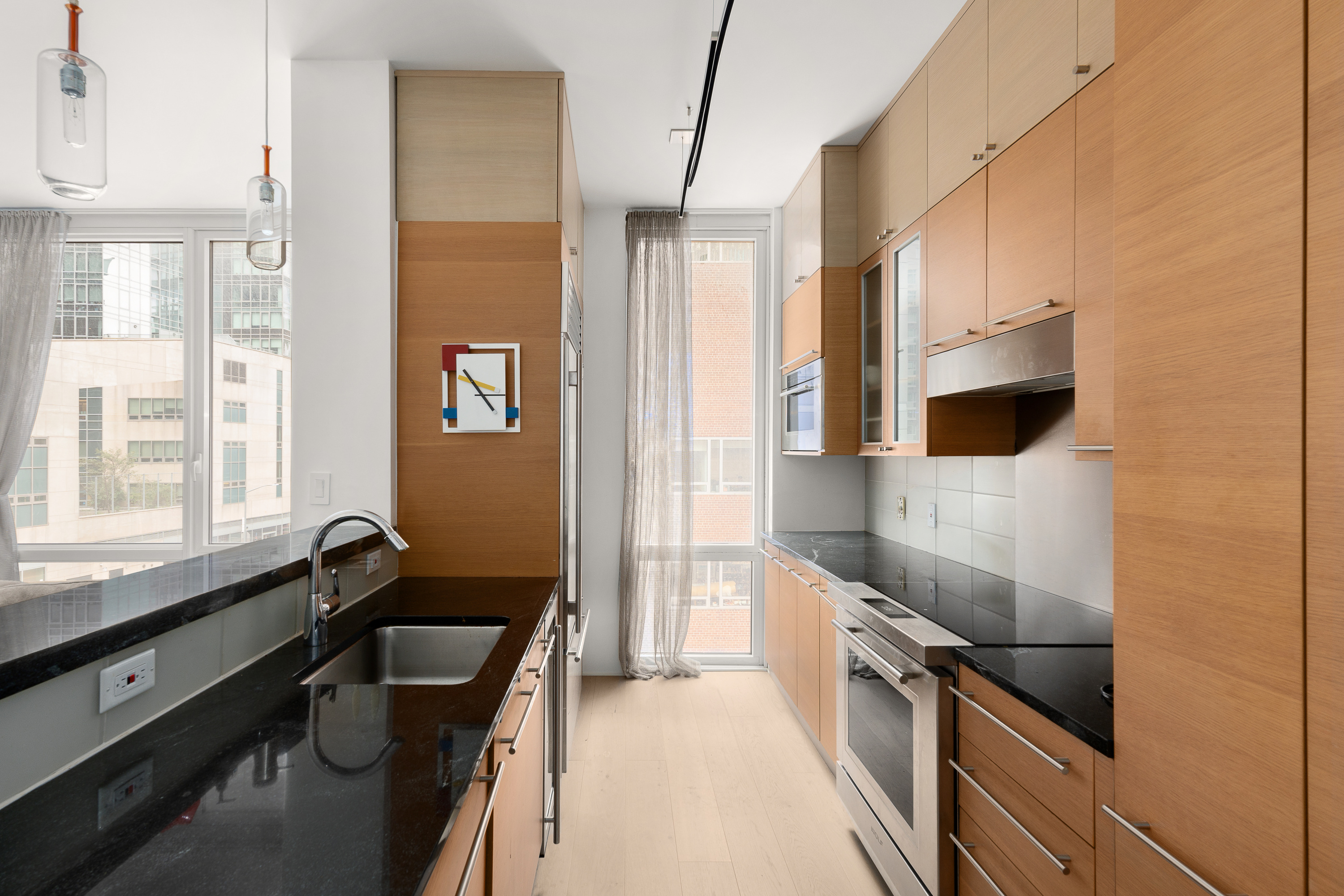 10 West End Avenue, Unit 4B Manhattan, NY 10023 - Photo 5 of 12 a kitchen with granite countertop a sink a counter top space stainless steel appliances a counter space and a window