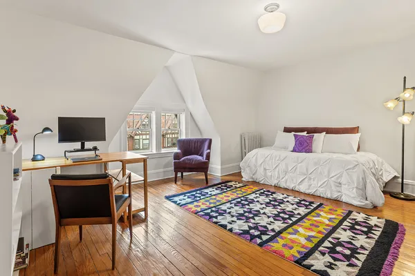 a bed sitting in a bedroom next to a window