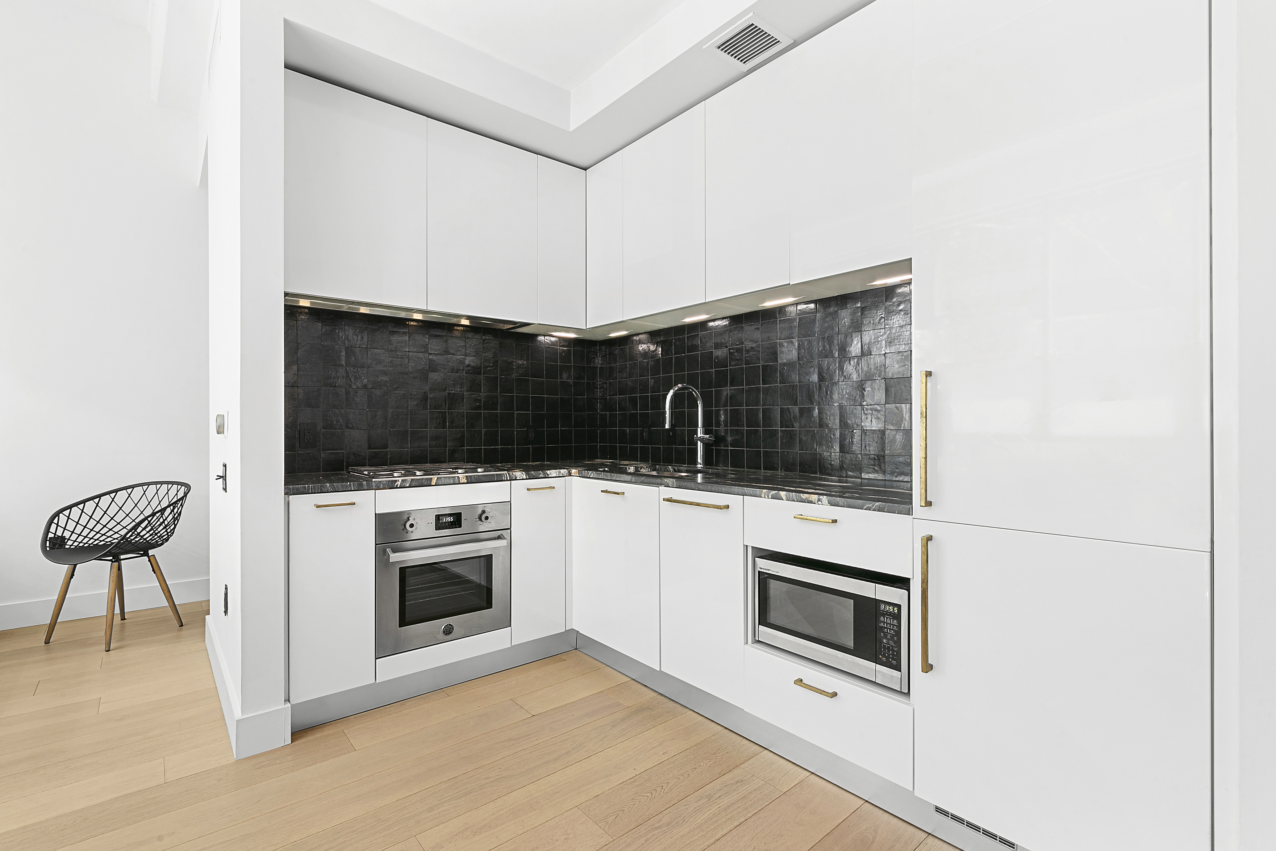 338 Berry Street, Unit 1B Brooklyn, NY 11249 - Photo 4 of 13 a kitchen with a stove and a microwave