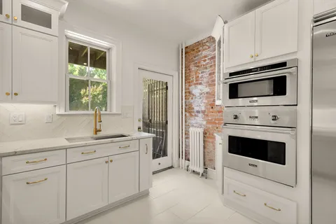 a kitchen with white cabinets stainless steel appliances and sink