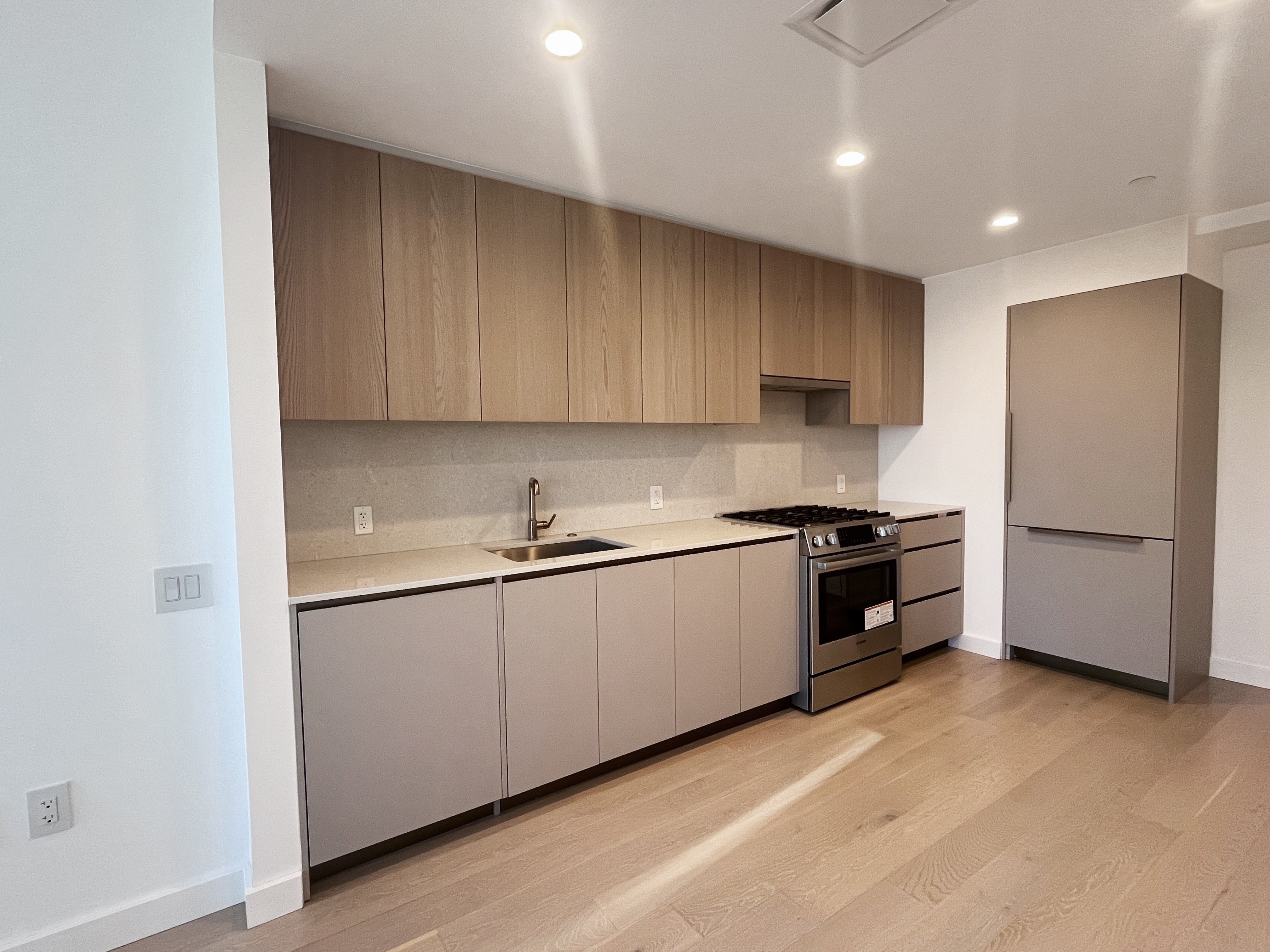 45-3 Court Square, Unit 5906 Queens, NY 11101 - Photo 2 of 12 a kitchen with a refrigerator and a sink