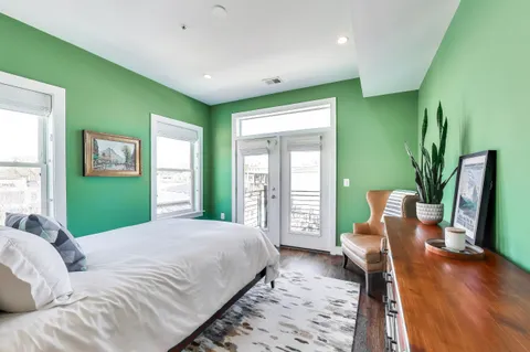 a large bedroom with a large bed and a potted plant