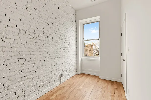 a bathroom with a wooden floor and a window