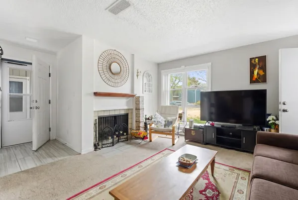 a living room with furniture a flat screen tv and a fireplace