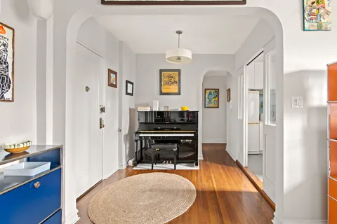 a dining room with wooden floor and a chandelier