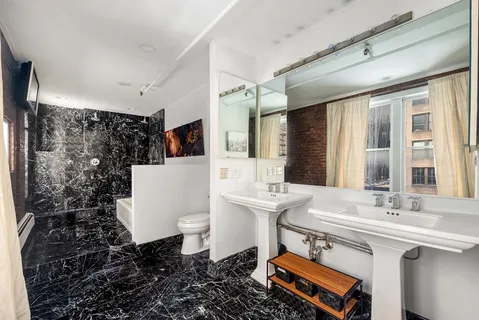 a bathroom with a sink toilet a mirror and shower