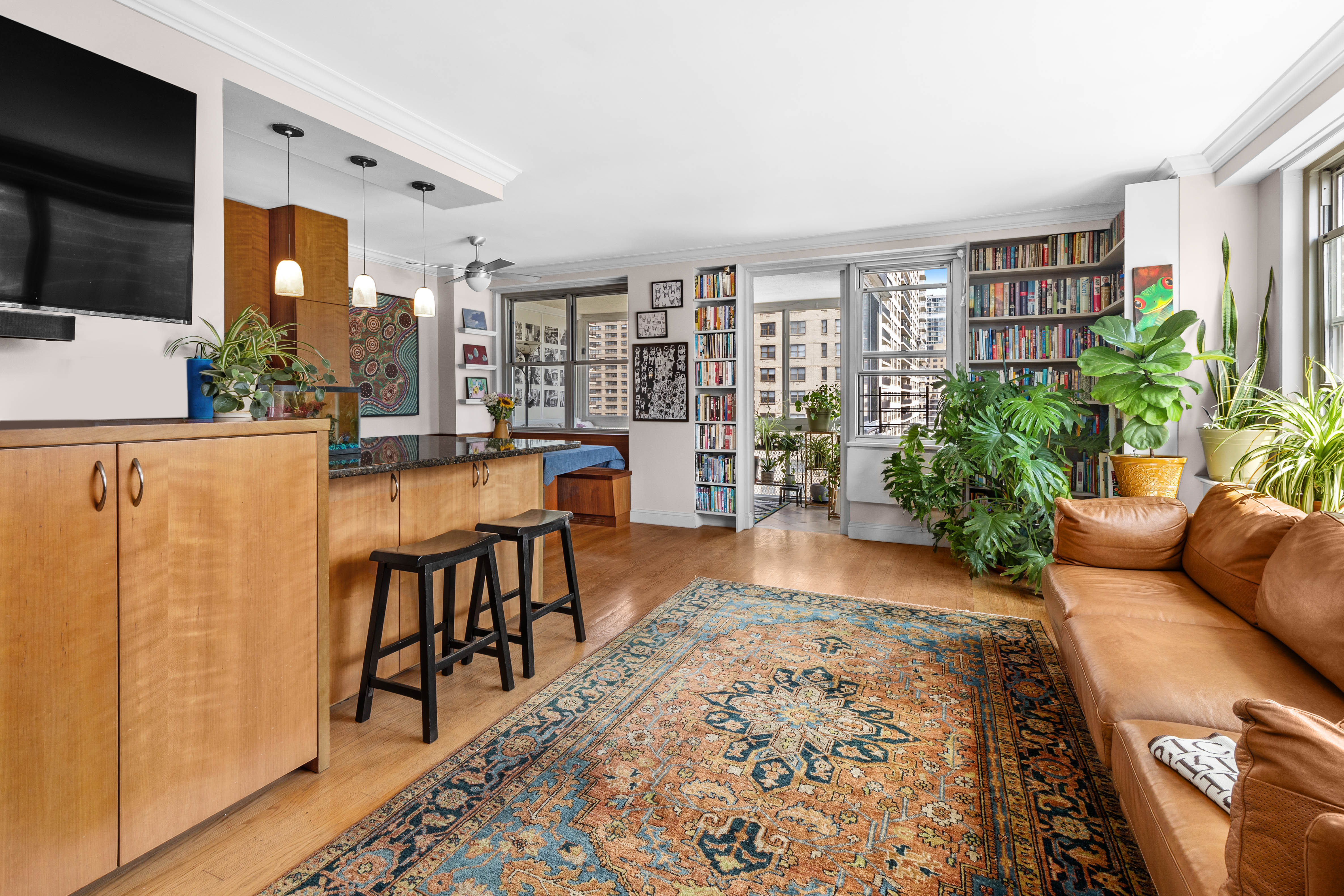 303 West 66th Street, Unit 18EE Manhattan, NY 10023 - Photo 5 of 24 a living room with furniture a flat screen tv and a floor to ceiling window