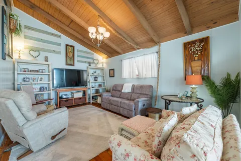 a living room with furniture a flat screen tv and a large window