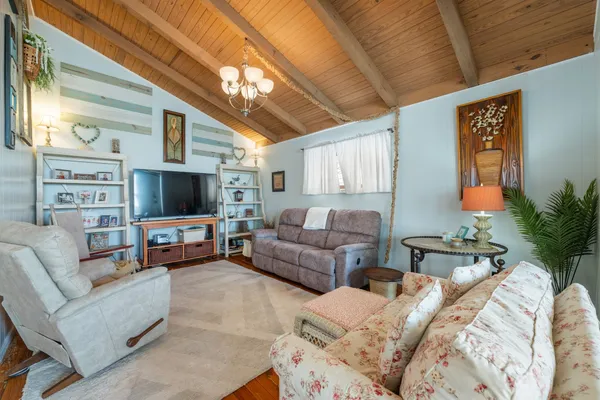 a living room with furniture a flat screen tv and a large window