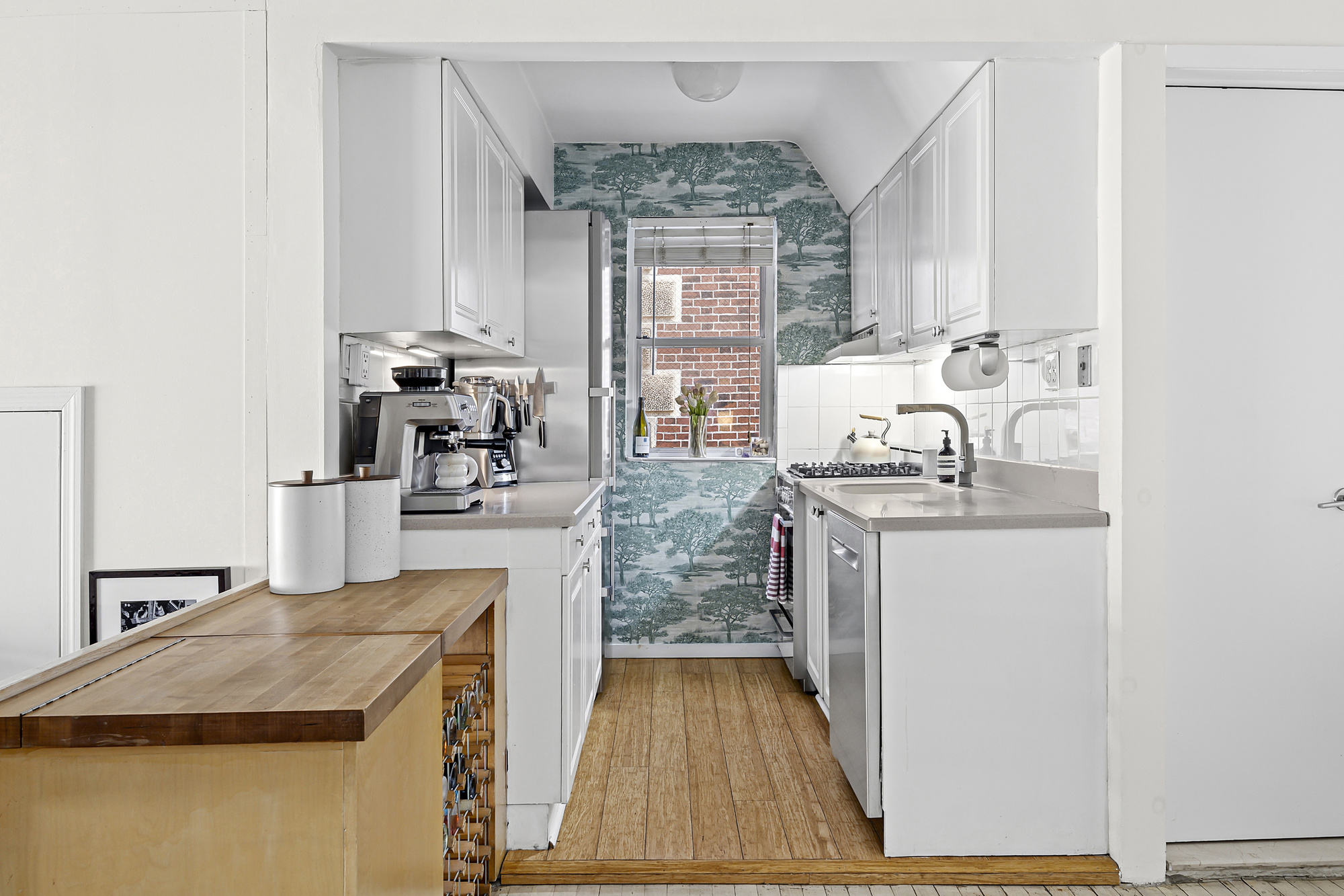 19 West 85th Street, Unit 3B Manhattan, NY 10024 - Photo 5 of 12 a kitchen with kitchen island granite countertop a sink stove and wooden cabinets