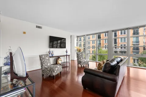 a view of a livingroom with furniture wooden floor windows and a chandelier