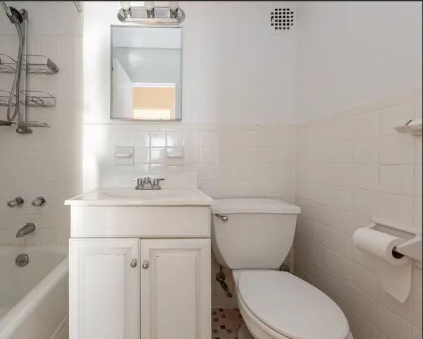 a bathroom with a toilet sink and mirror