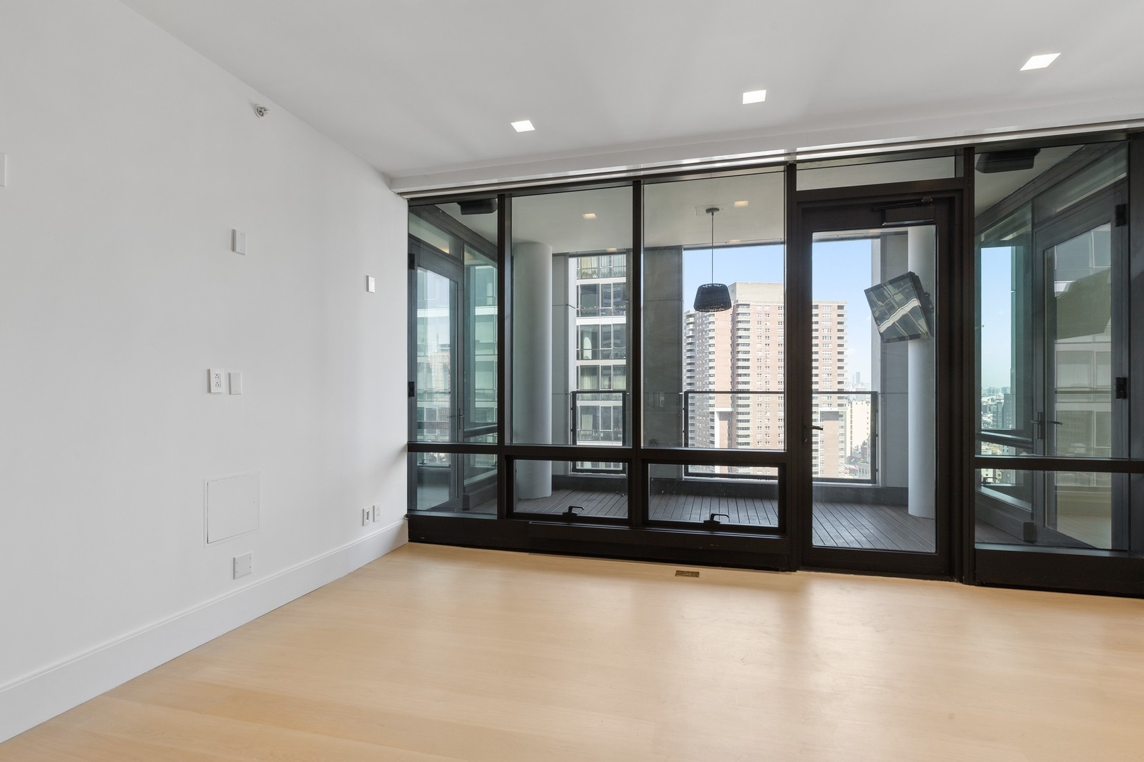 101 Warren Street, Unit 2420 Manhattan, NY 10007 - Photo 12 of 23 an empty room with wooden floor and entrance