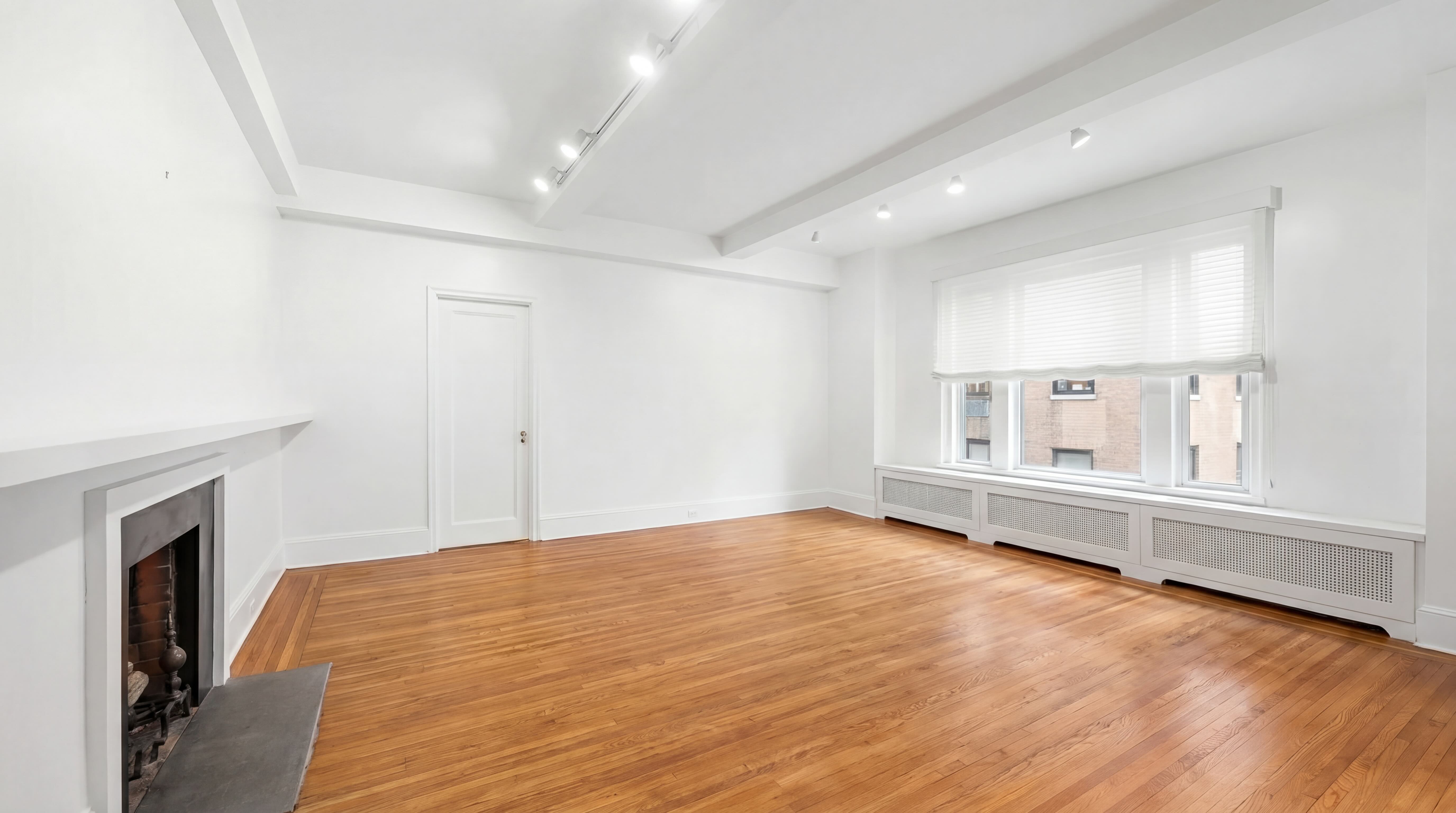 77 Park Avenue, Unit 6H Manhattan, NY 10016 - Photo 3 of 9 a view of an empty room with window and wooden floor