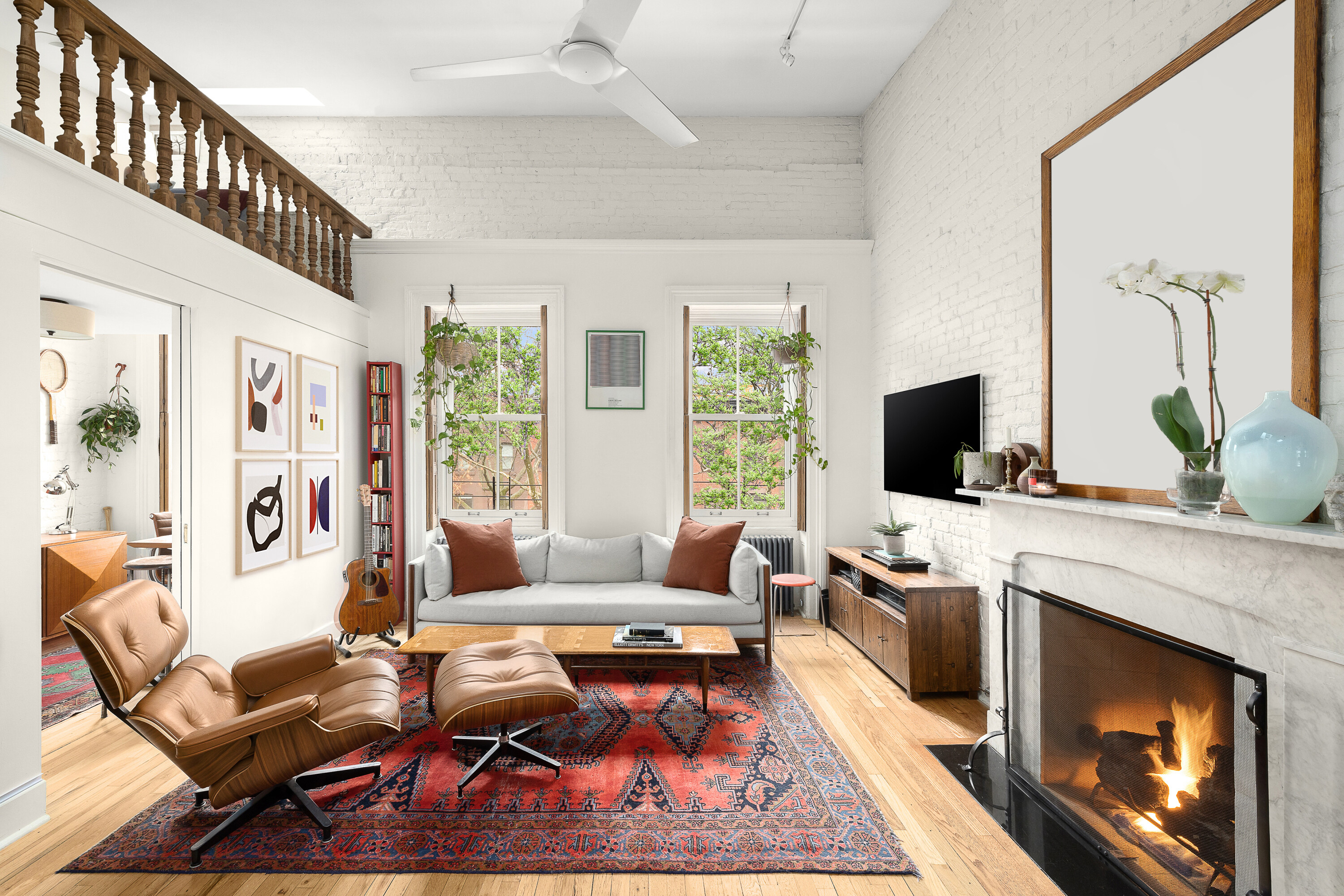 a living room with furniture a flat screen tv and a fireplace