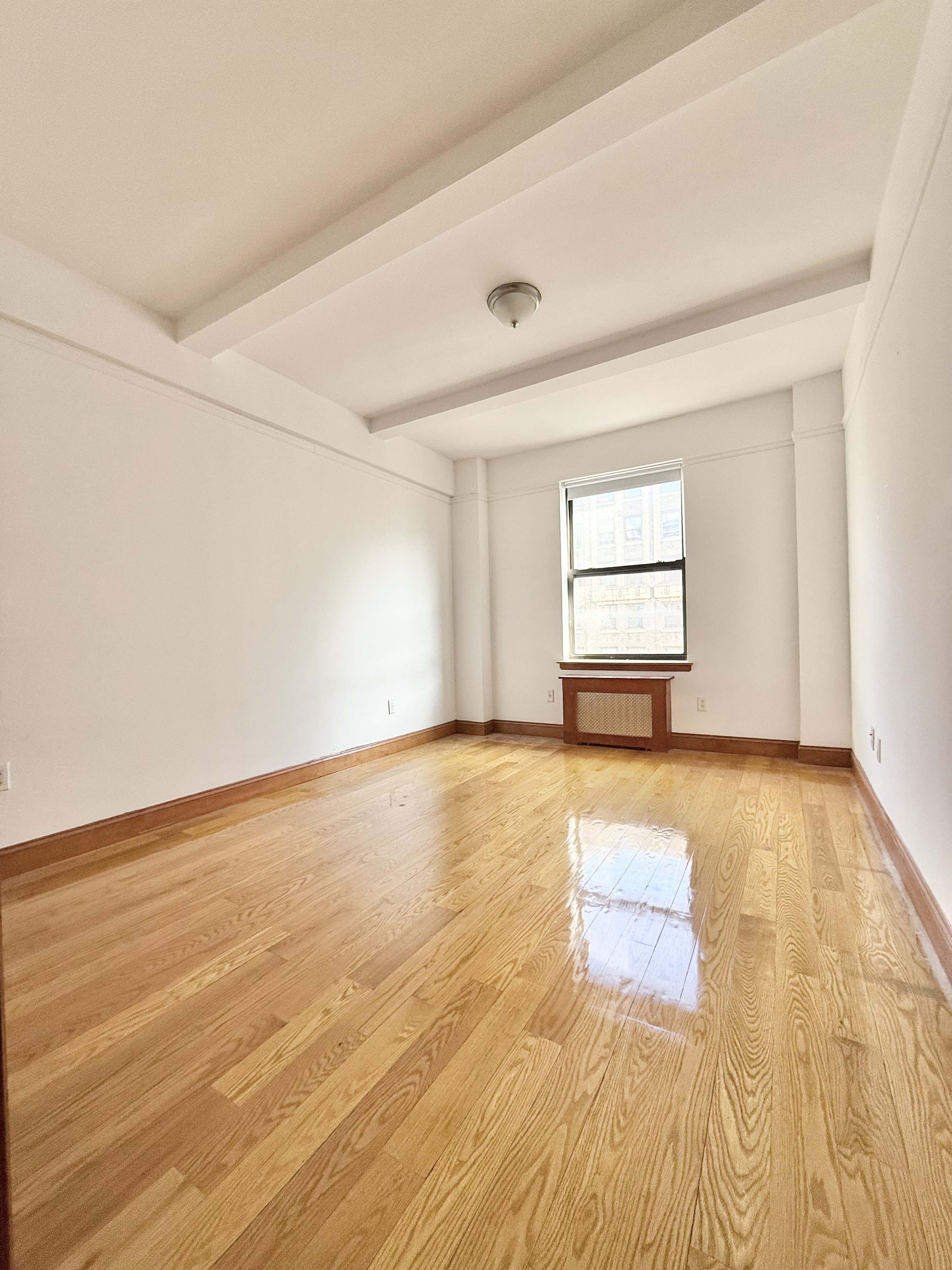 675 West End Avenue, Unit 12A Manhattan, NY 10025 - Photo 6 of 15 an empty room with wooden floor and windows