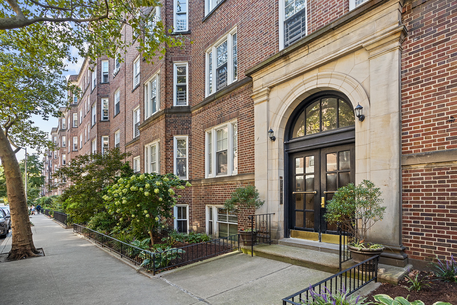 35-16 79th Street, Unit 1 Queens, NY 11372 - Photo 11 of 14 a view of a brick house with plants and large tree