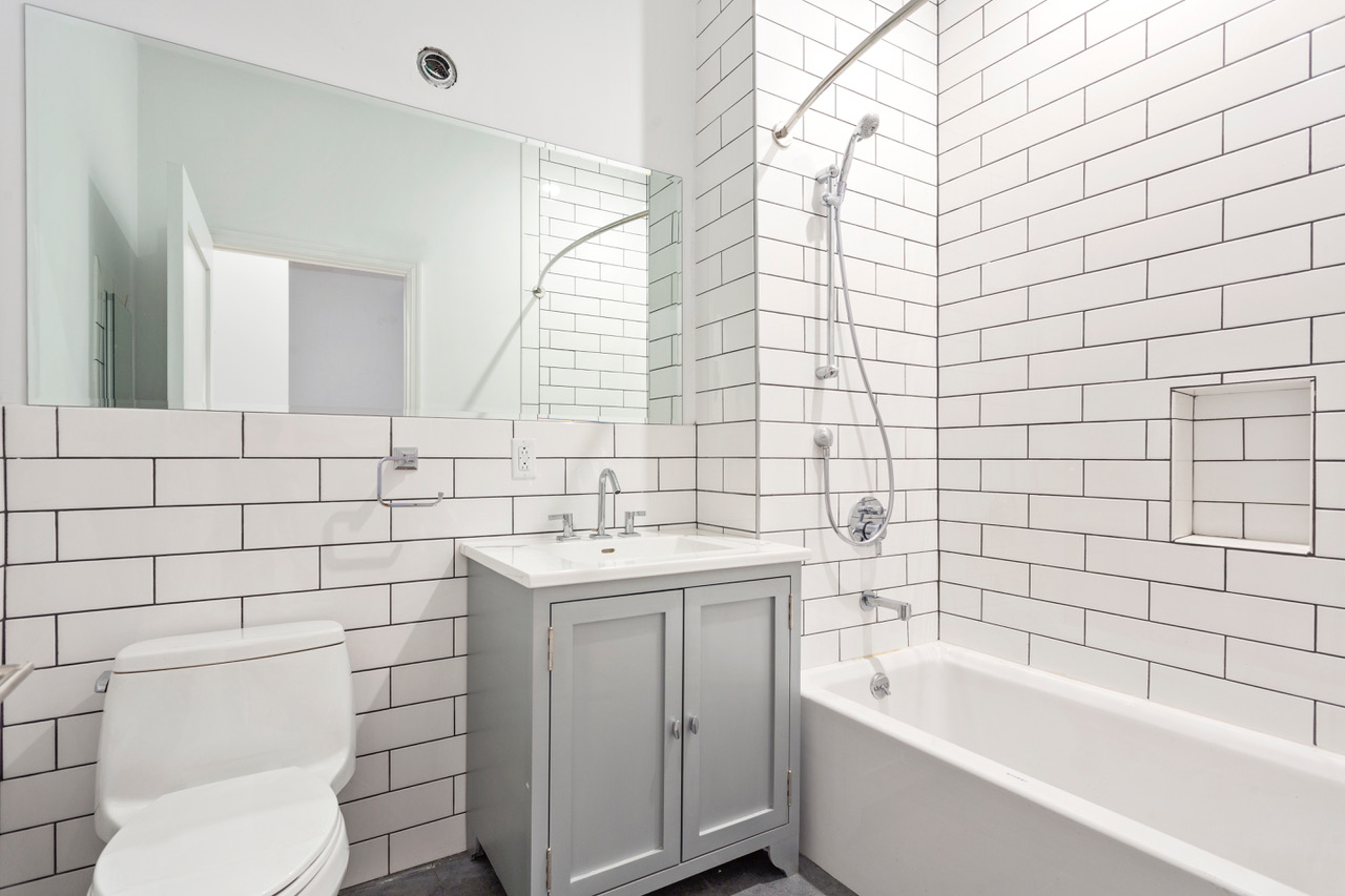 281 Grand Street, Unit 2R Manhattan, NY 10002 - Photo 2 of 11 a bathroom with a sink a toilet and mirror