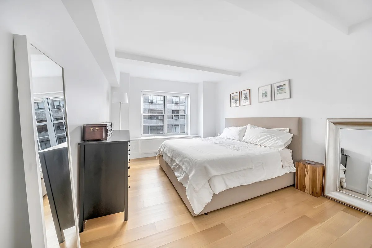 12 East 88th Street, Unit 6C Manhattan, NY 10128 - Photo 6 of 15 a bedroom with a bed and wooden floor