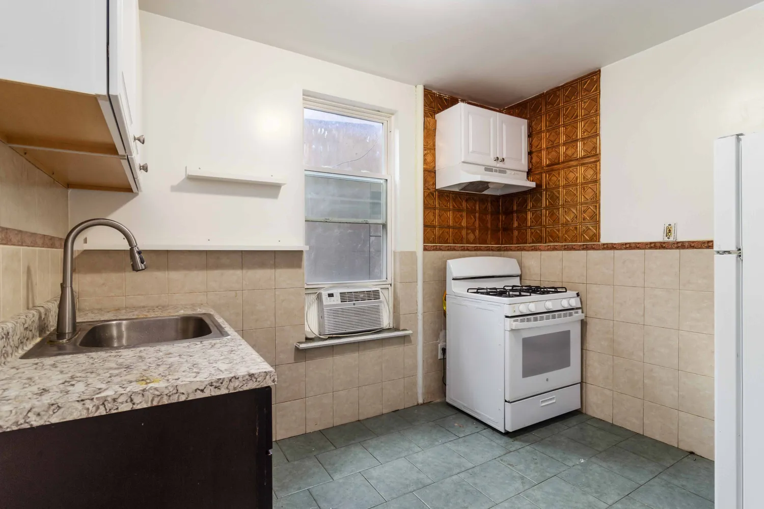 a kitchen with granite countertop a sink and a stove top oven