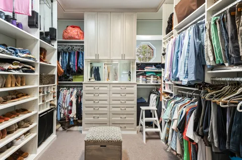 a view of walk in closet with clothes and shoes