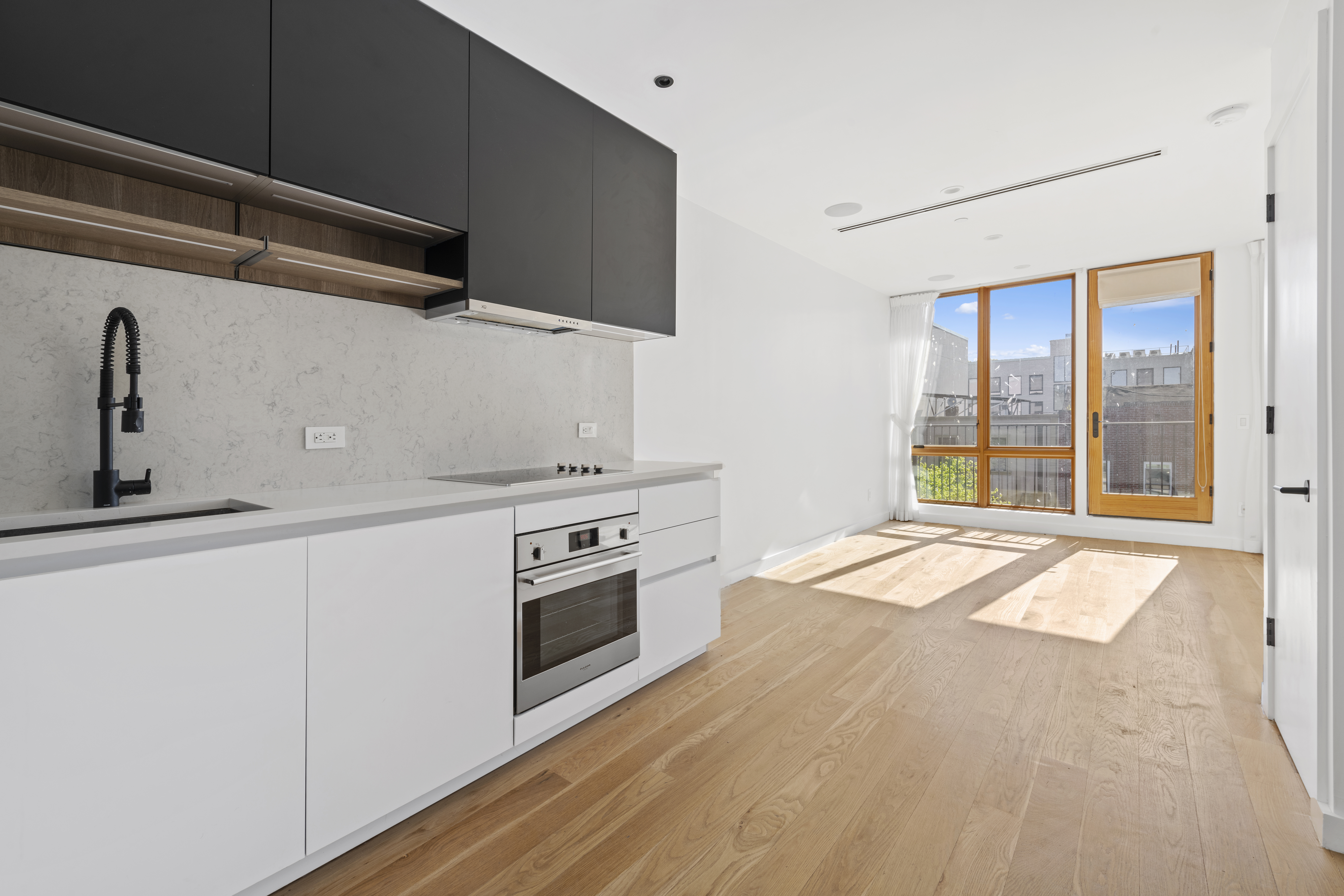 42 Rochester Avenue, Unit 3 Brooklyn, NY 11233 - Photo 11 of 18 a view of a kitchen with a stove wooden floor and staircase