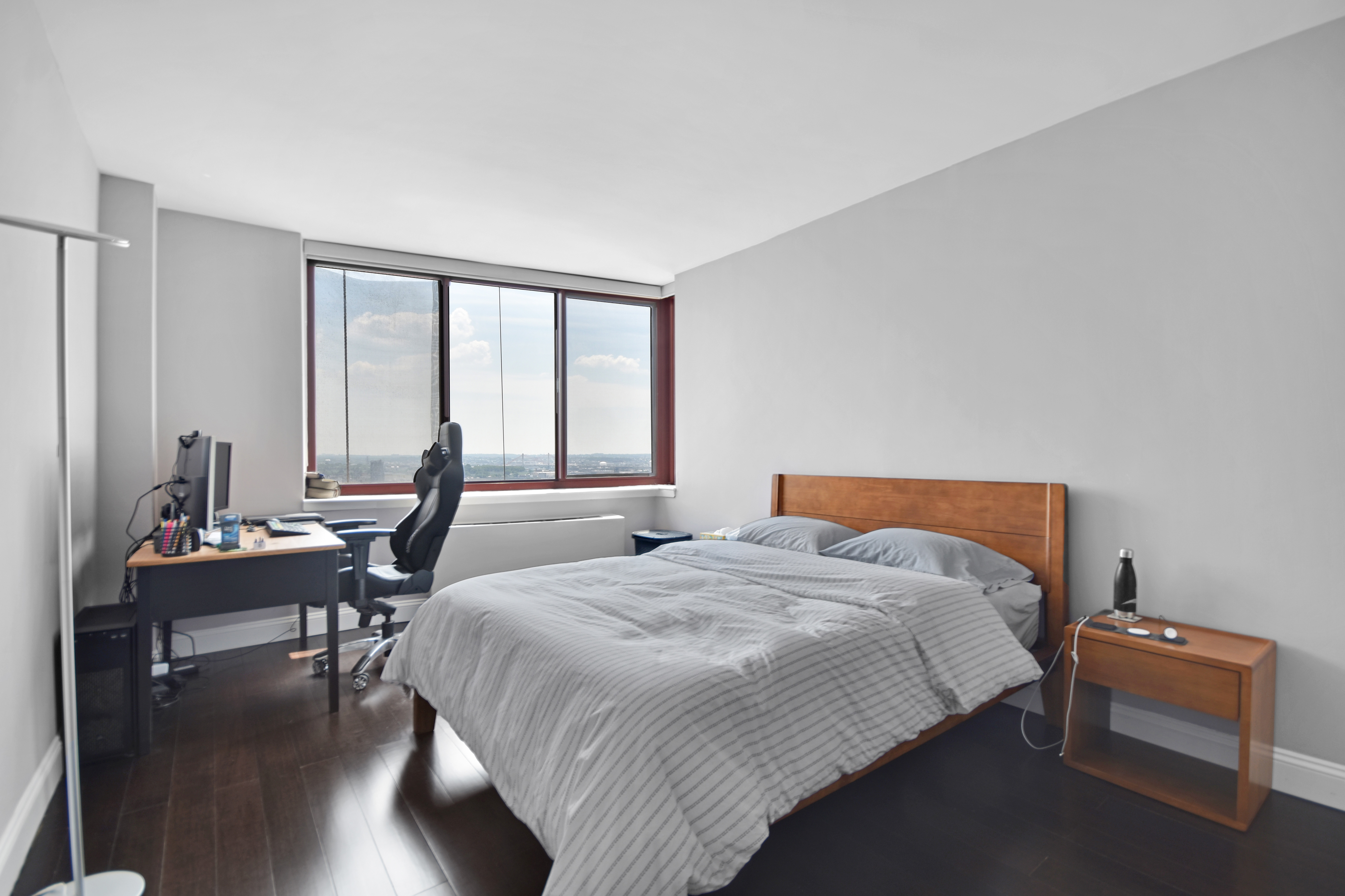 4-74 48th Avenue, Unit 34G Queens, NY 11109 - Photo 7 of 9 a bedroom with a bed and a desk