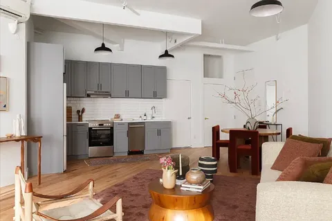 a living room with stainless steel appliances kitchen island granite countertop furniture and a kitchen view