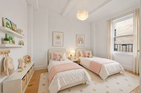 a bedroom with two beds and a large window