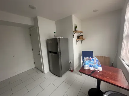 a bedroom with a bed table chair and a window