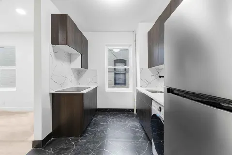 a room with a sink and a refrigerator