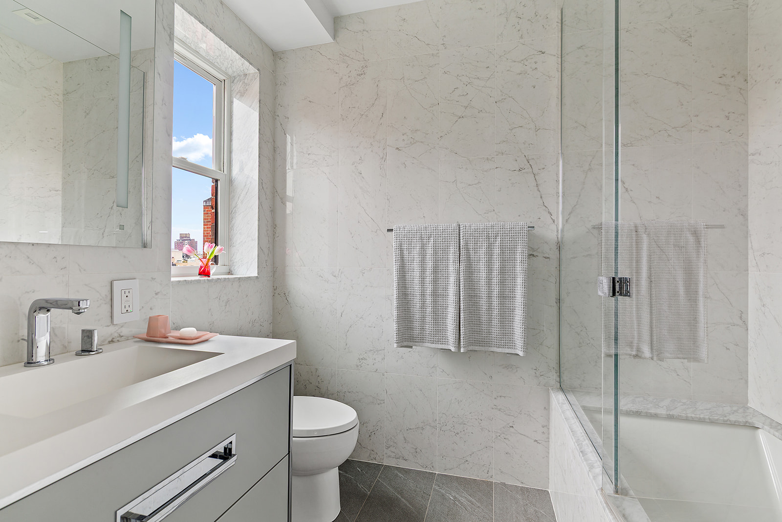 165 East 72nd Street, Unit 17L Manhattan, NY 10021 - Photo 10 of 12 a bathroom with a sink a toilet and shower