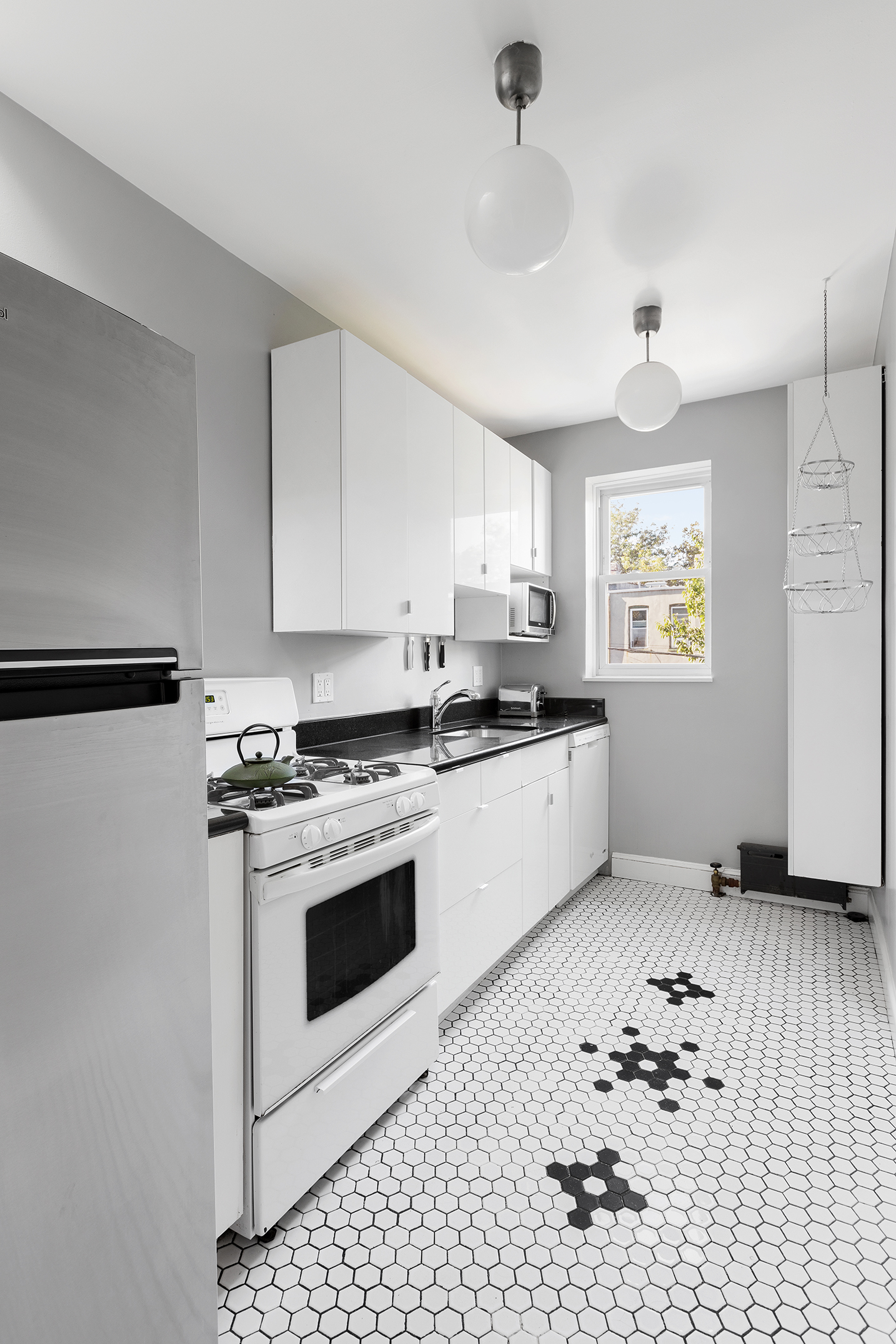 195 Lefferts Avenue Brooklyn, NY 11225 - Photo 13 of 18 a kitchen with granite countertop a stove a sink and a microwave