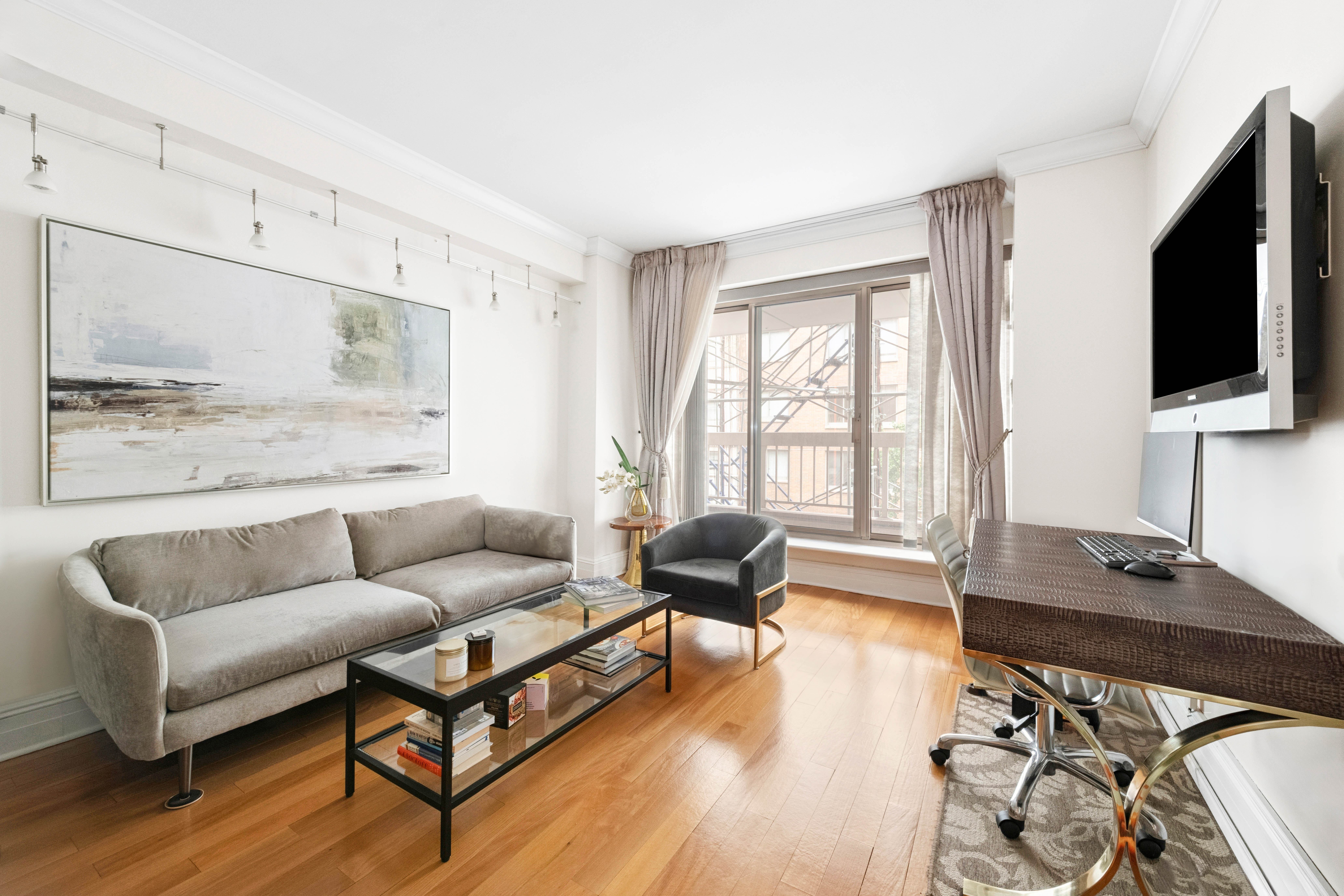 200 East 69th Street, Unit 4N Manhattan, NY 10021 - Photo 2 of 13 a living room with furniture and a flat screen tv