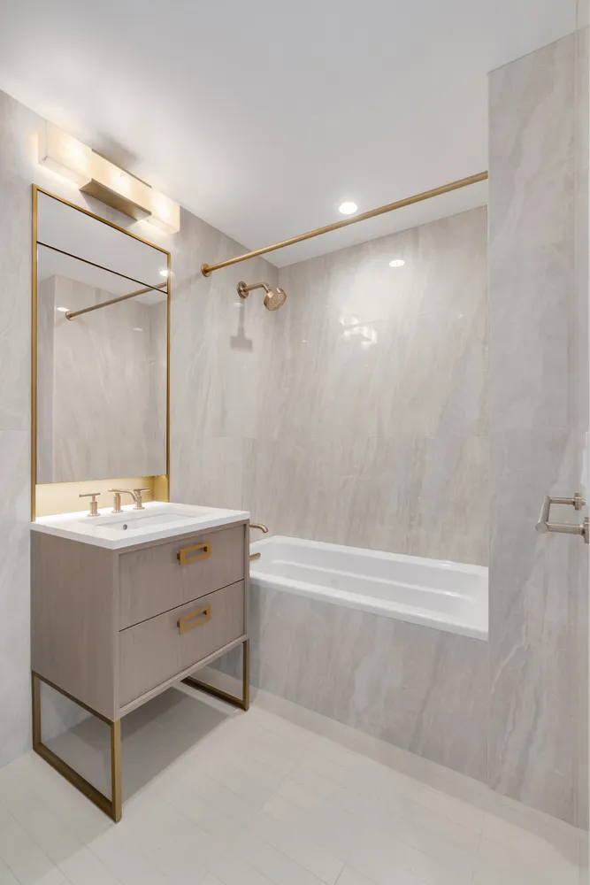 a bathroom with a tub sink and mirror