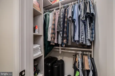 a view of walk in closet with clothes and shoes