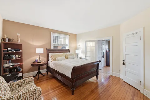 a bedroom with a bed and wooden floor