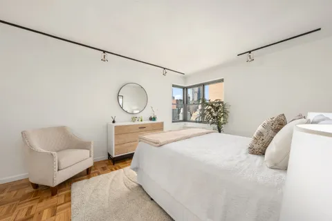 a bedroom with a bed couch and window