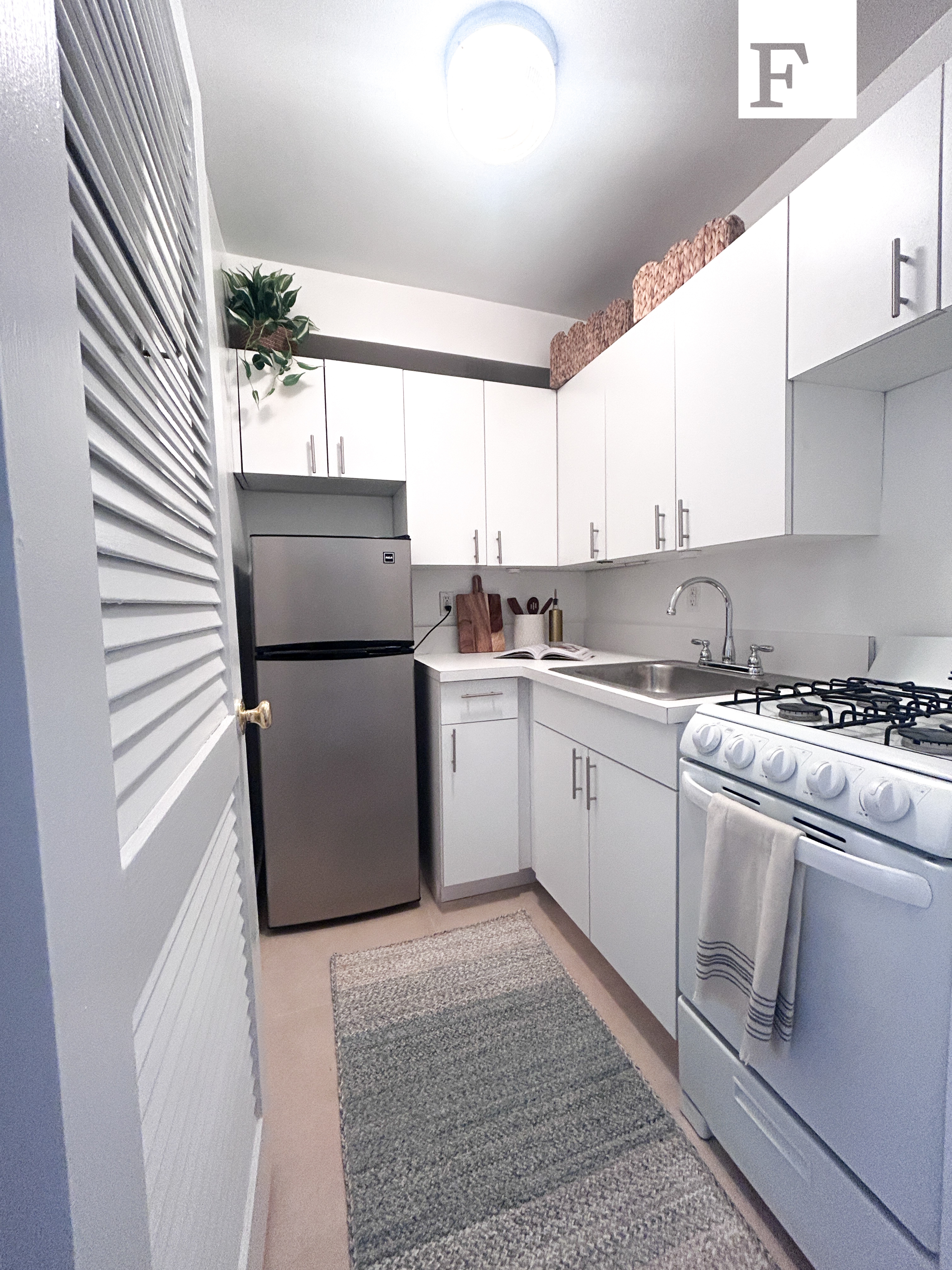 25 West 13th Street, Unit 6KS Manhattan, NY 10011 - Photo 5 of 8 a kitchen with a white cabinets and white appliances