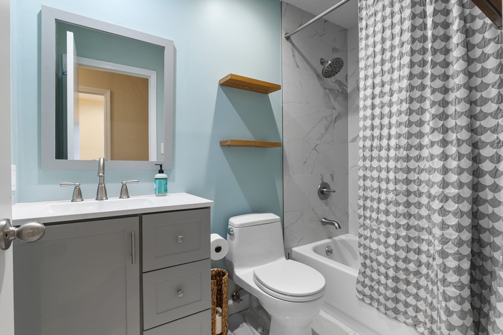 2 Clarendon Street, Unit 401 Boston, MA 02116 - Photo 7 of 13 a bathroom with a granite countertop toilet a sink and a mirror