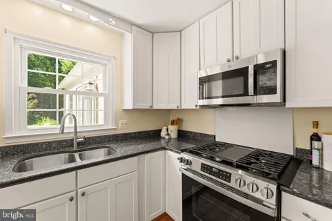 a view of kitchen with sink microwave and refrigerator
