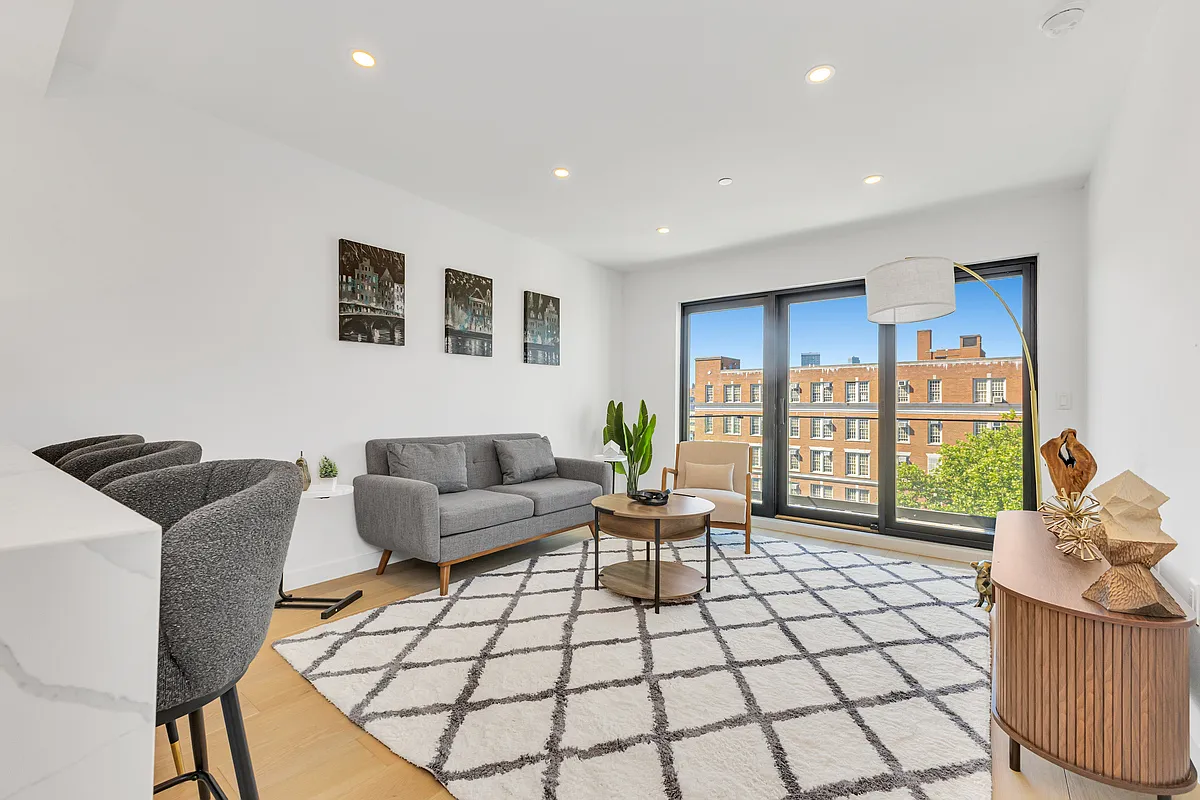 21-10 31st Avenue, Unit 6R Queens, NY 11106 - Photo 6 of 17 a living room with furniture and a floor to ceiling window