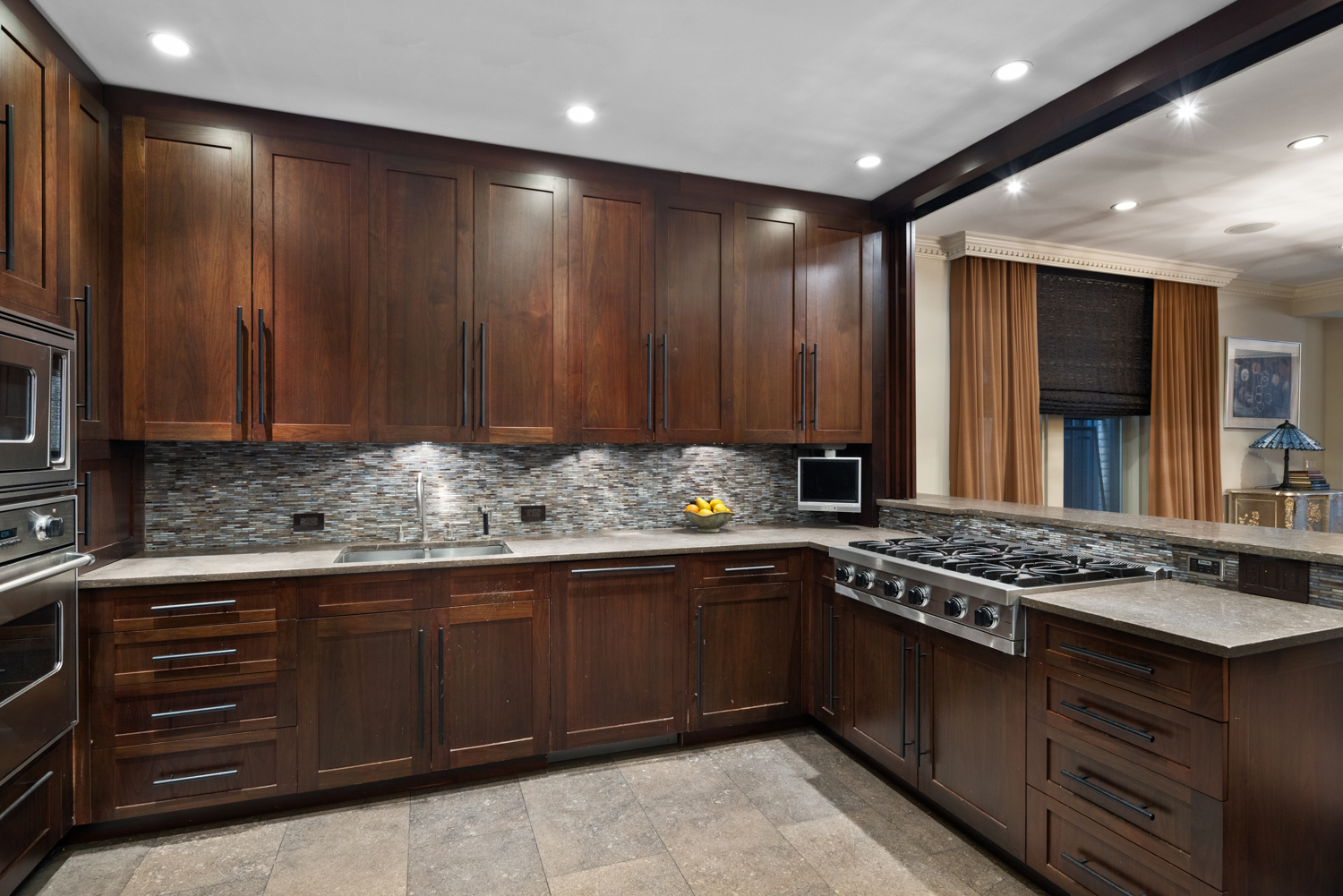 333 Central Park West, Unit 11 Manhattan, NY 10025 - Photo 10 of 21 a kitchen with stainless steel appliances granite countertop wooden cabinets and a stove top oven
