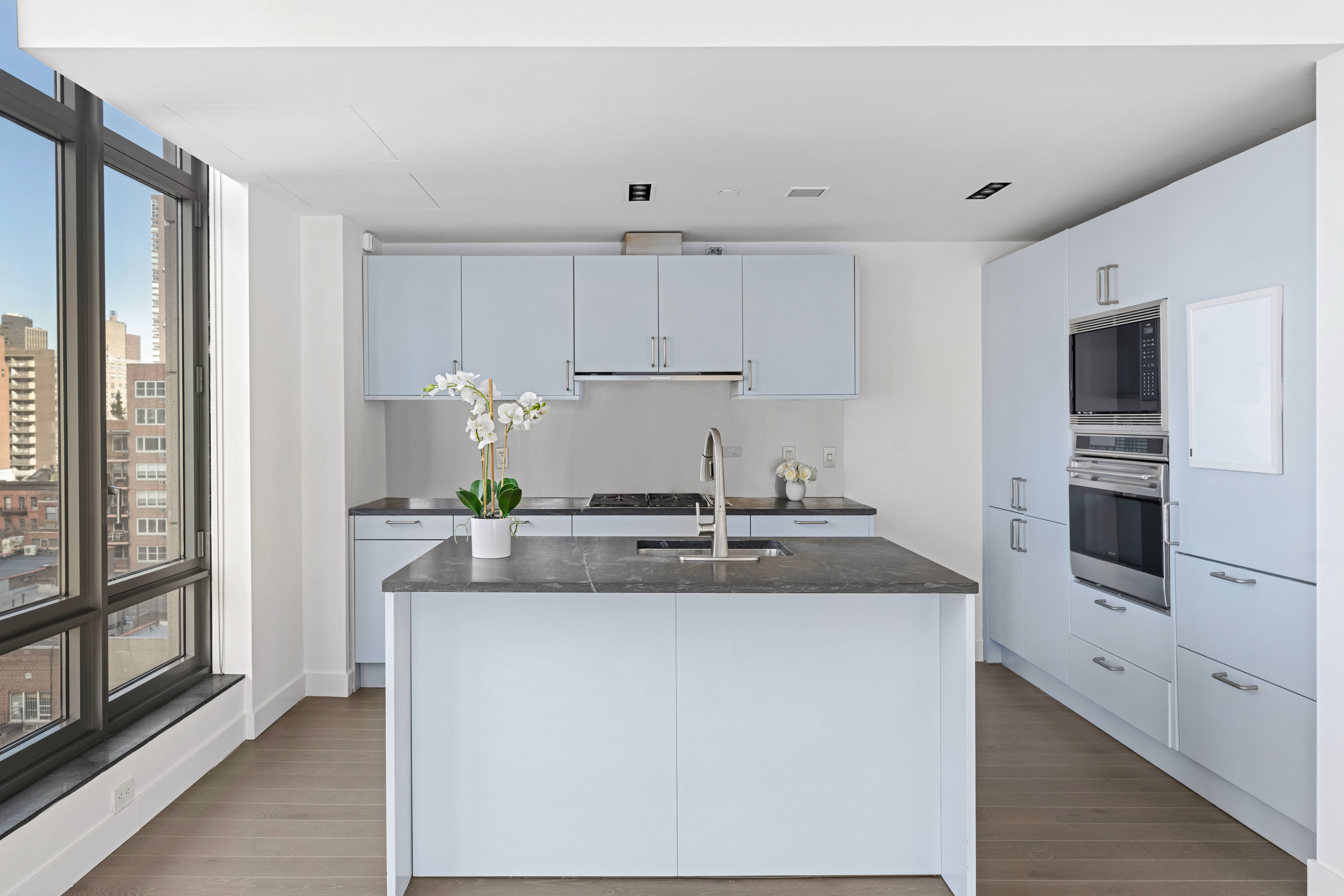 450 East 83rd Street, Unit 9E Manhattan, NY 10028 - Photo 4 of 18 a kitchen with kitchen island granite countertop a sink and refrigerator