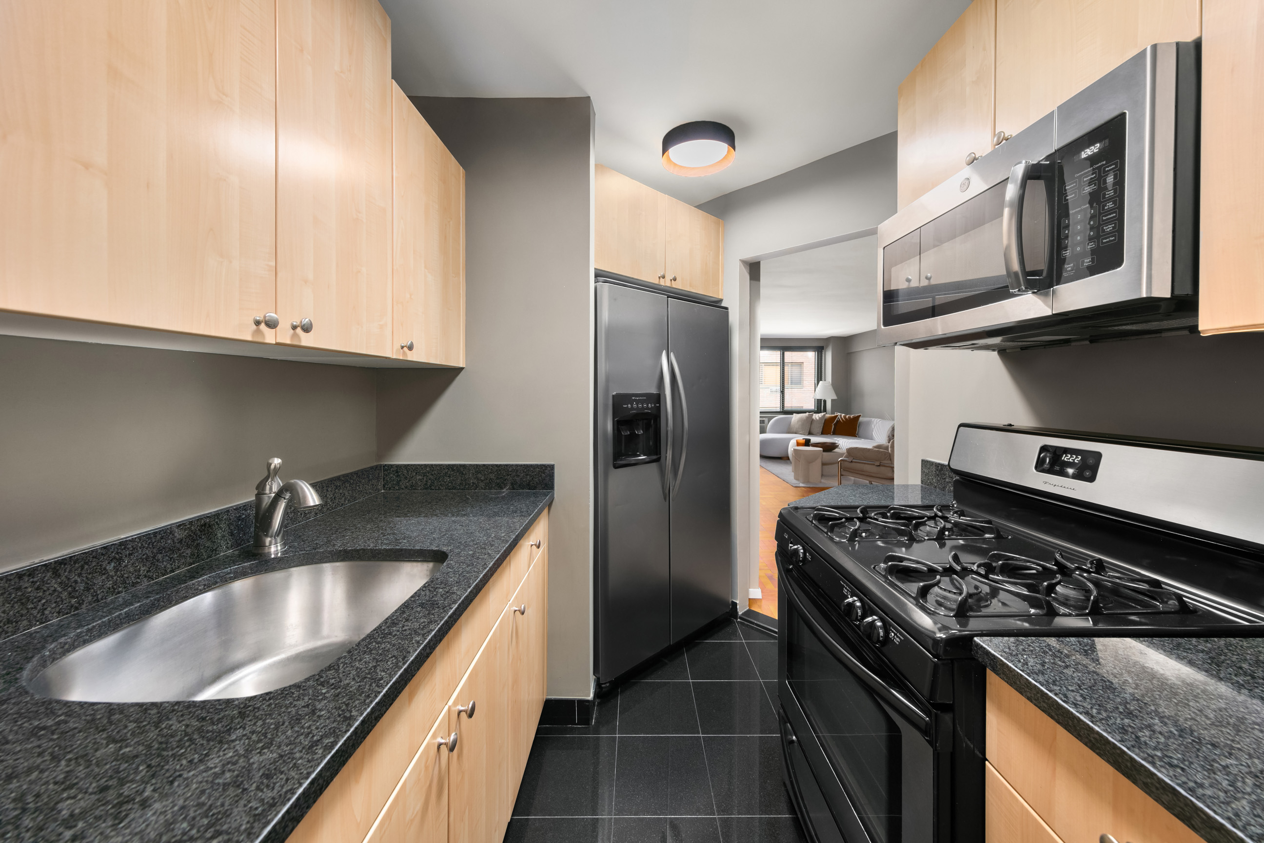 420 East 64th Street, Unit E3A Manhattan, NY 10065 - Photo 4 of 8 a kitchen with stainless steel appliances granite countertop a sink stove and refrigerator