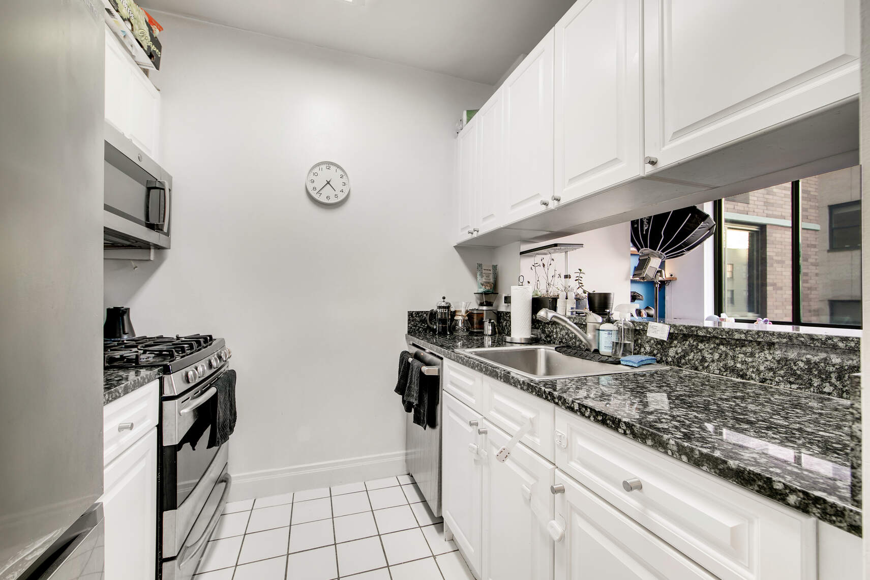 400 East 90th Street, Unit 9A Manhattan, NY 10128 - Photo 4 of 11 a kitchen with stainless steel appliances granite countertop a sink stove and cabinets