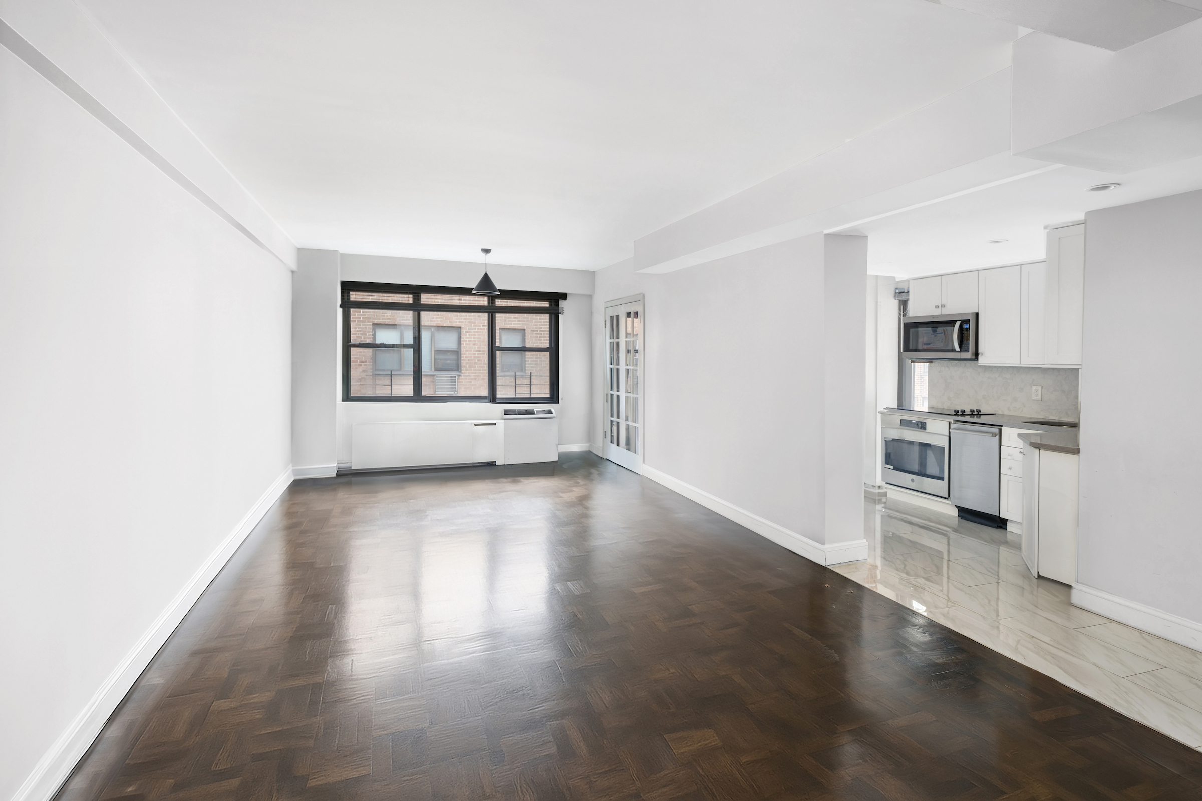 2 Tudor City Place, Unit 11KN Manhattan, NY 10017 - Photo 8 of 14 an empty room with wooden floor and windows